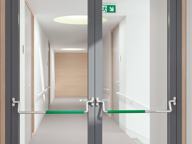 Double glass door equipped with two stainless steel panic bars with green polyamide handle tube